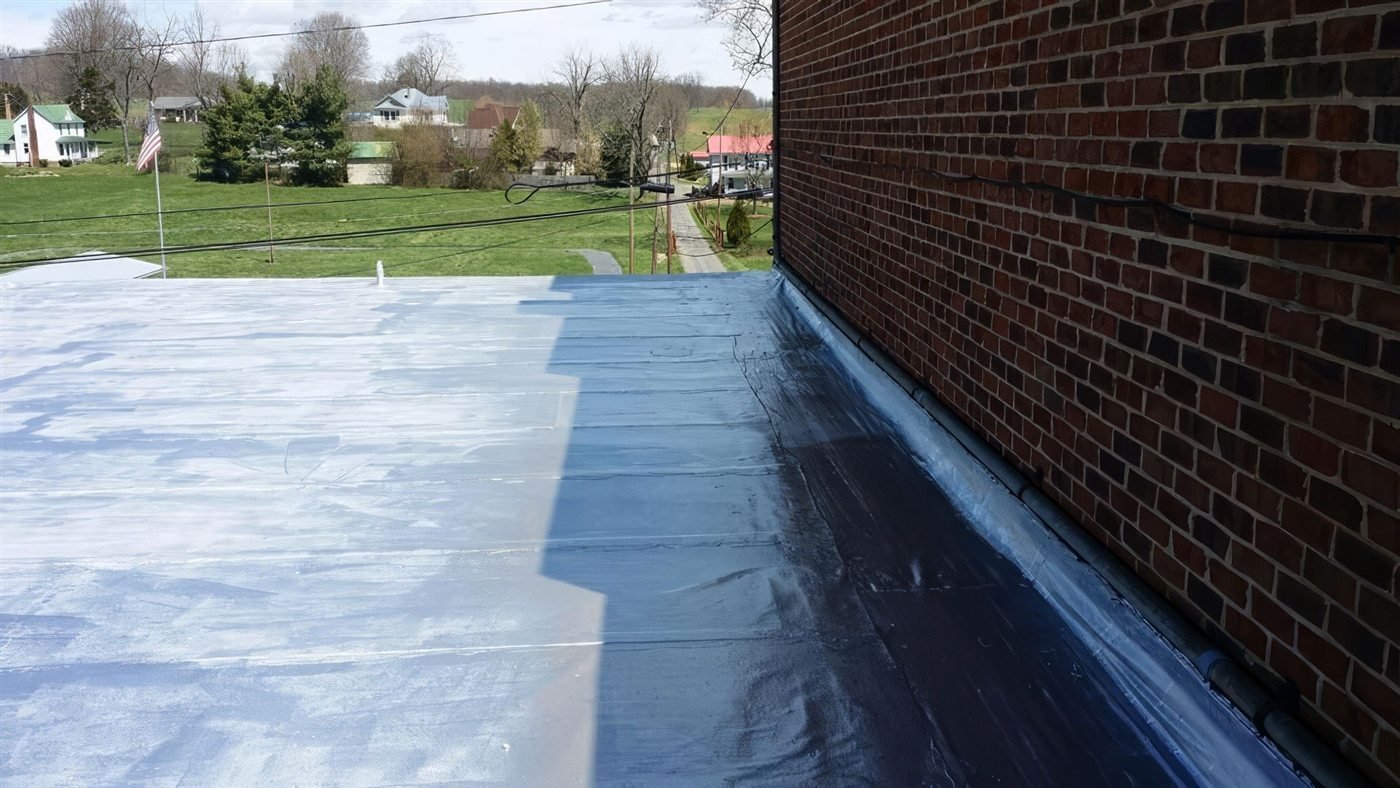 Coated low-slope roof against a brick parapet on a Virginia commercial building