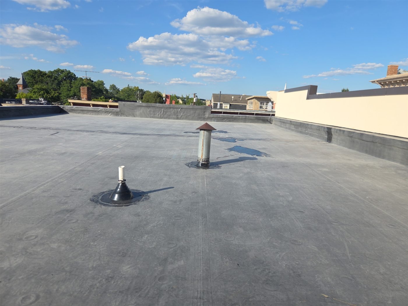 Pipe boot penetrations on a flat roof, a common source of leaks