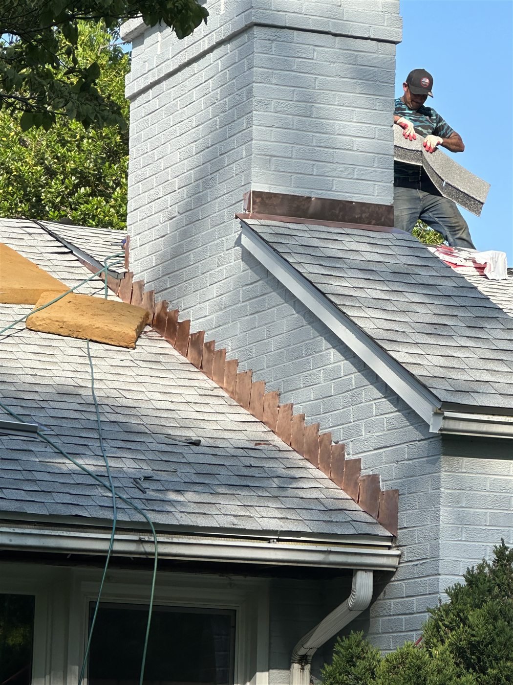 Installing shingles alongside new copper step flashing